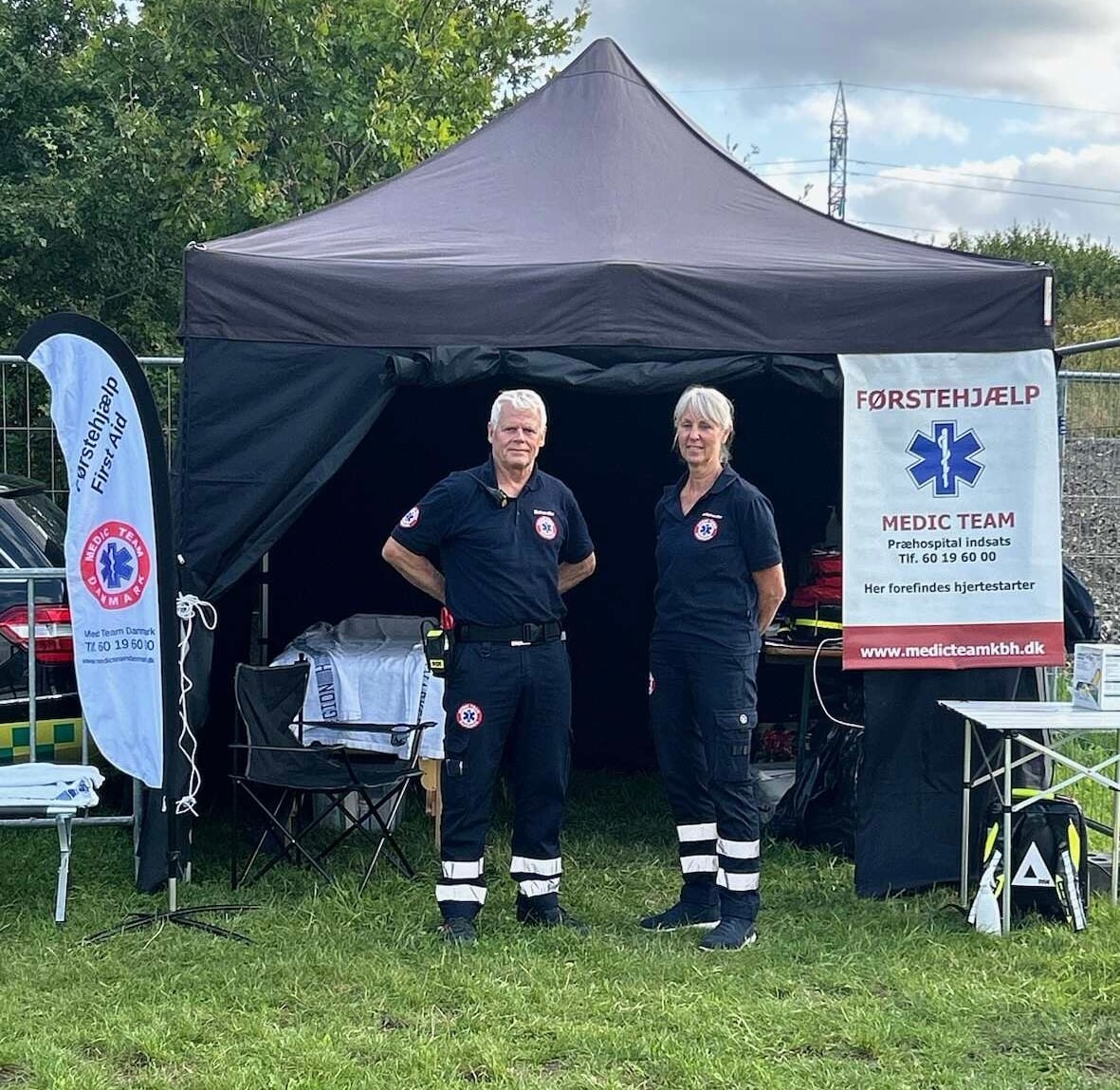 To medlemmer af Medic Team Danmark foran en behandlingsplads i et telt